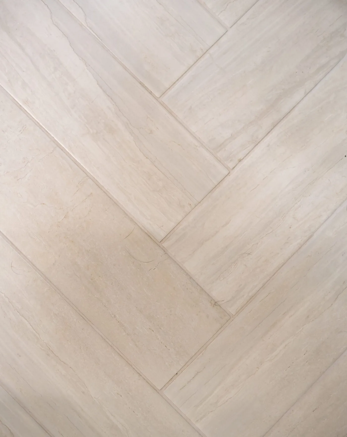 Herringbone pattern tile flooring in a remodeled bathroom