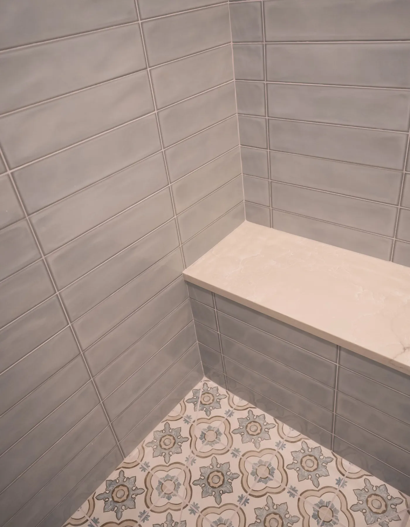 Walk-in tiled shower with a frosted glass door and low threshold